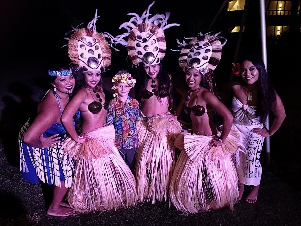 Caleb in the middle of Luau dancers